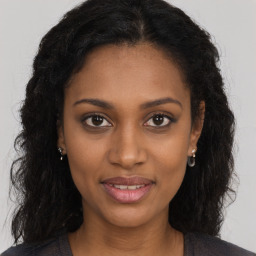 Joyful black young-adult female with long  brown hair and brown eyes