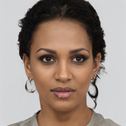 Joyful black young-adult female with short  black hair and brown eyes