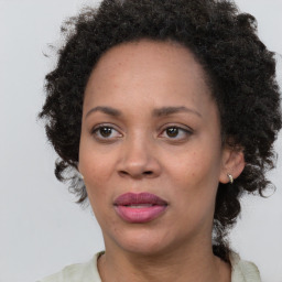 Joyful black adult female with medium  brown hair and brown eyes