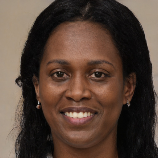 Joyful black young-adult female with long  black hair and brown eyes