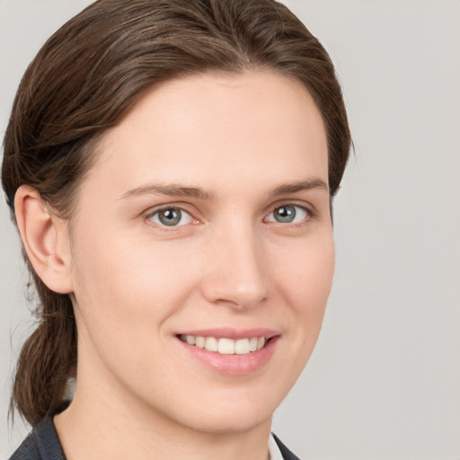 Joyful white young-adult female with medium  brown hair and grey eyes