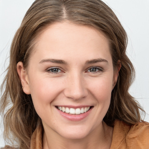 Joyful white young-adult female with long  brown hair and grey eyes