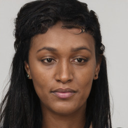 Joyful black young-adult female with long  brown hair and brown eyes