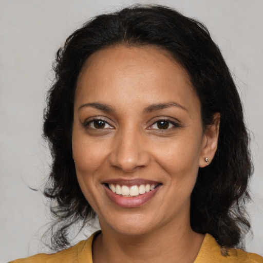 Joyful latino adult female with medium  brown hair and brown eyes