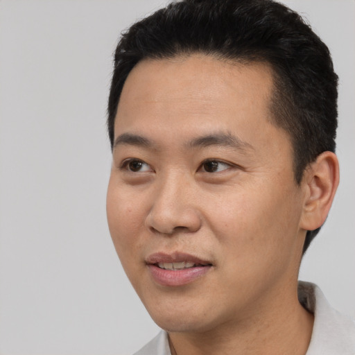 Joyful asian young-adult male with short  black hair and brown eyes
