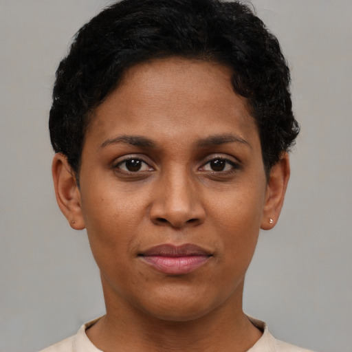 Joyful black young-adult female with short  black hair and brown eyes