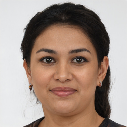 Joyful latino adult female with medium  brown hair and brown eyes