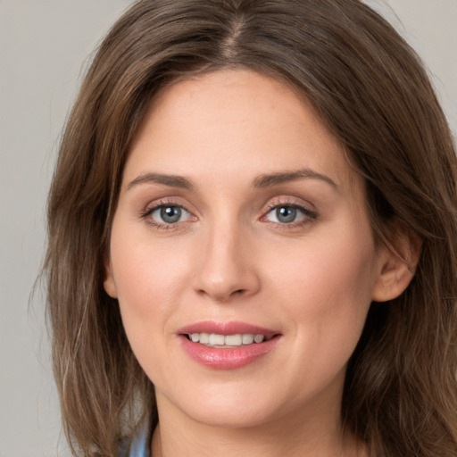 Joyful white young-adult female with long  brown hair and green eyes