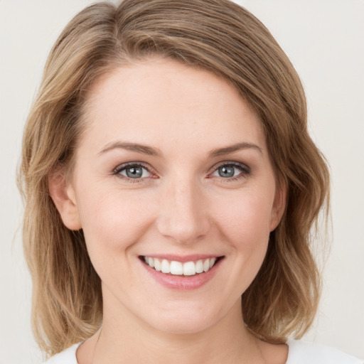 Joyful white young-adult female with medium  brown hair and green eyes