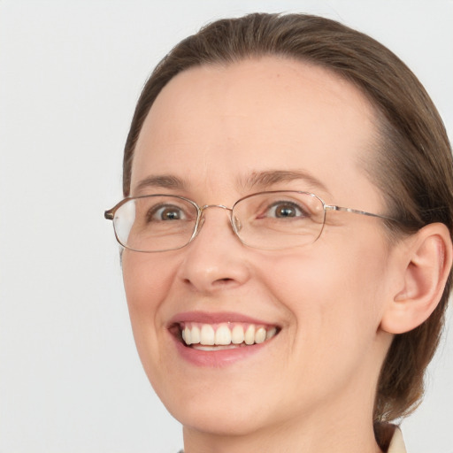 Joyful white adult female with medium  brown hair and blue eyes