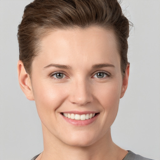 Joyful white young-adult female with short  brown hair and grey eyes