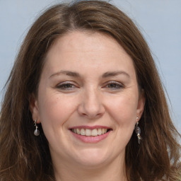 Joyful white adult female with long  brown hair and grey eyes