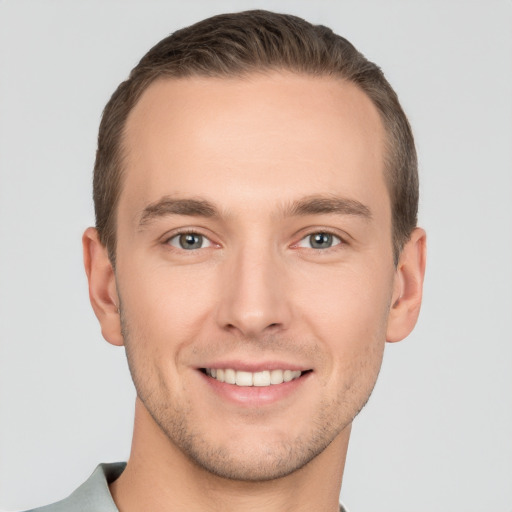 Joyful white young-adult male with short  brown hair and grey eyes