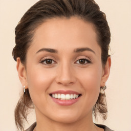 Joyful white young-adult female with long  brown hair and brown eyes