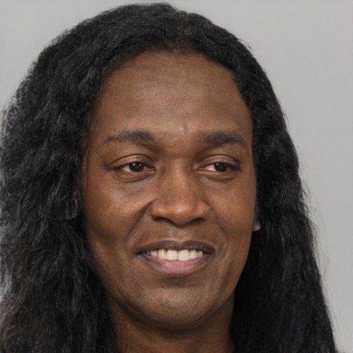 Joyful black adult male with long  black hair and brown eyes