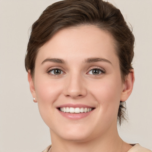 Joyful white young-adult female with short  brown hair and grey eyes