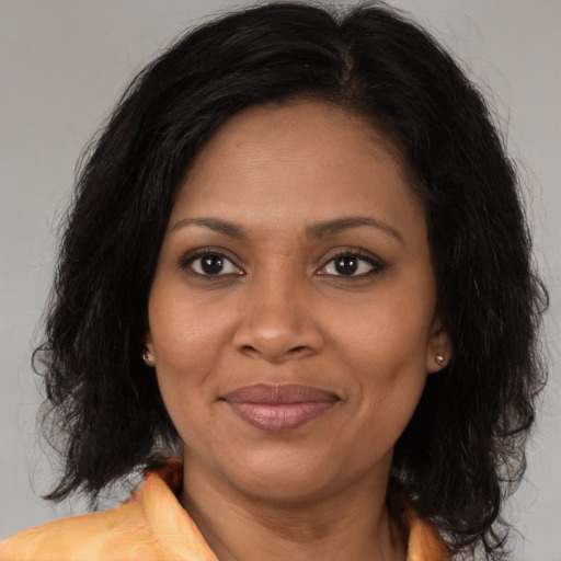 Joyful black adult female with medium  brown hair and brown eyes