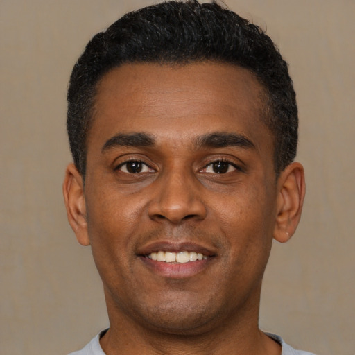 Joyful latino young-adult male with short  black hair and brown eyes