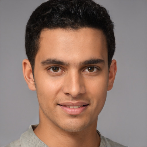 Joyful latino young-adult male with short  brown hair and brown eyes