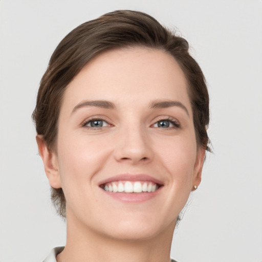 Joyful white young-adult female with short  brown hair and grey eyes