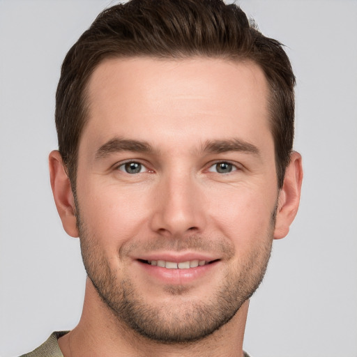 Joyful white young-adult male with short  brown hair and grey eyes