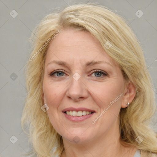 Joyful white adult female with medium  brown hair and blue eyes