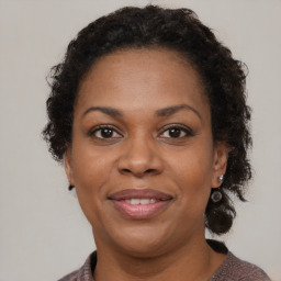 Joyful black adult female with medium  brown hair and brown eyes