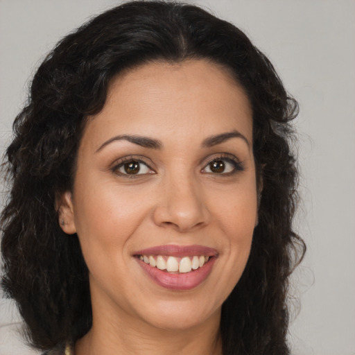 Joyful latino young-adult female with medium  brown hair and brown eyes