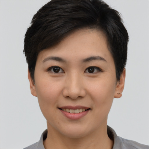 Joyful asian young-adult female with short  brown hair and brown eyes