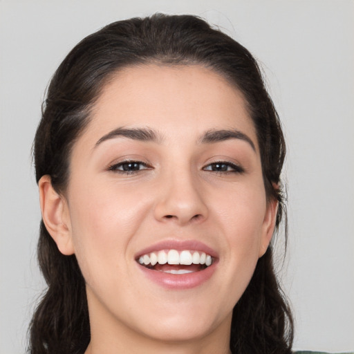 Joyful white young-adult female with long  brown hair and brown eyes