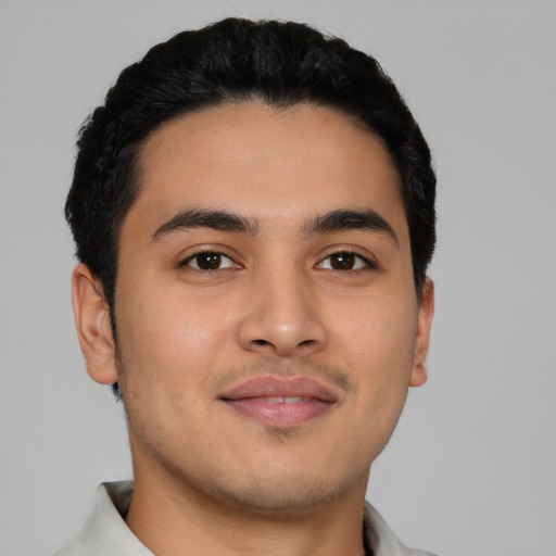 Joyful latino young-adult male with short  black hair and brown eyes