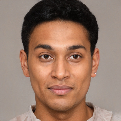 Joyful latino young-adult male with short  black hair and brown eyes