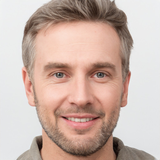 Joyful white adult male with short  brown hair and grey eyes