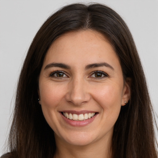 Joyful white young-adult female with long  brown hair and brown eyes