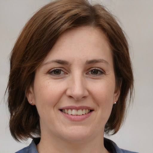 Joyful white adult female with medium  brown hair and brown eyes