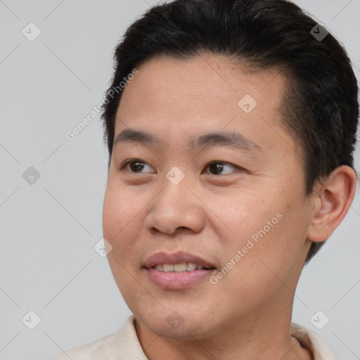 Joyful asian young-adult male with short  brown hair and brown eyes
