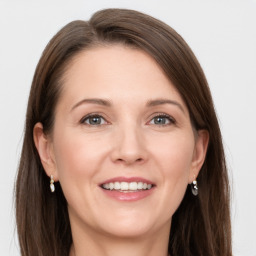 Joyful white adult female with long  brown hair and grey eyes