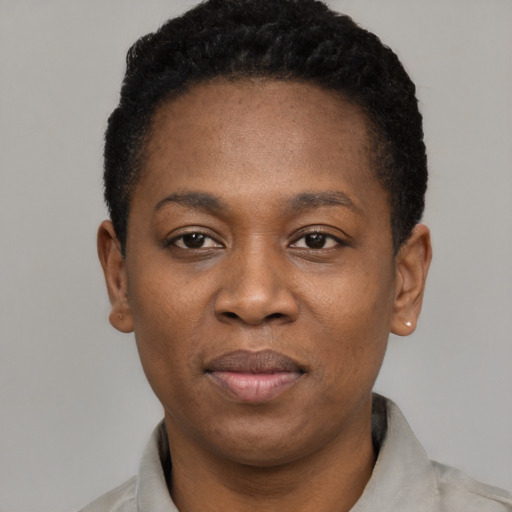 Joyful black young-adult female with short  black hair and brown eyes