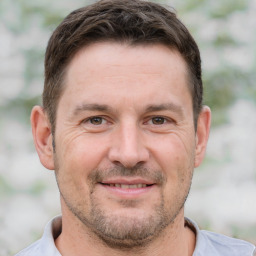 Joyful white adult male with short  brown hair and brown eyes