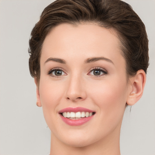 Joyful white young-adult female with medium  brown hair and green eyes