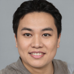 Joyful asian young-adult male with short  black hair and brown eyes