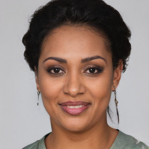 Joyful black young-adult female with short  black hair and brown eyes
