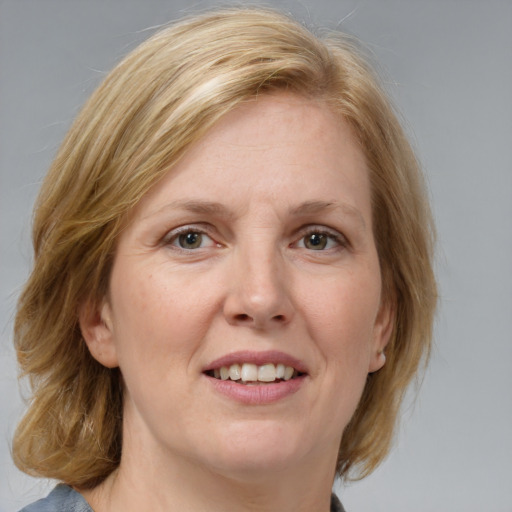 Joyful white adult female with medium  brown hair and blue eyes