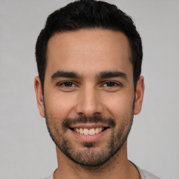 Joyful white young-adult male with short  black hair and brown eyes