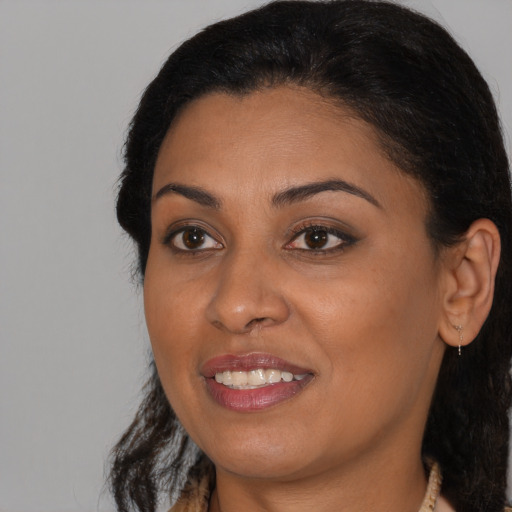 Joyful black young-adult female with medium  brown hair and brown eyes