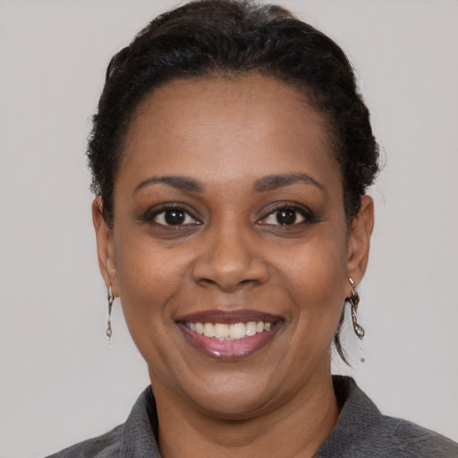 Joyful black adult female with short  black hair and brown eyes