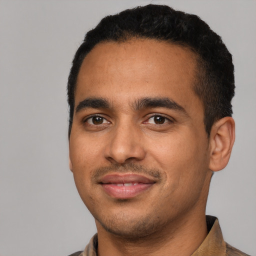 Joyful latino young-adult male with short  black hair and brown eyes