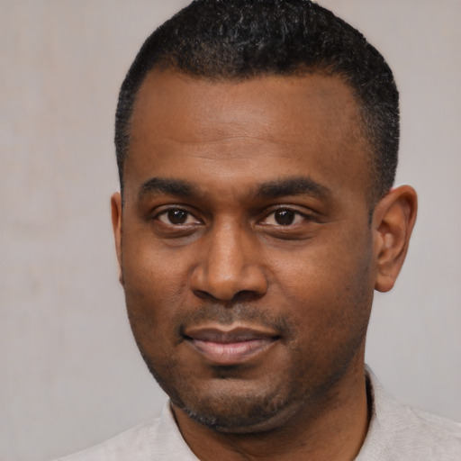 Joyful black young-adult male with short  black hair and brown eyes