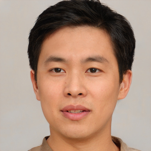 Joyful asian young-adult male with short  brown hair and brown eyes