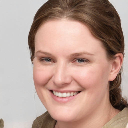 Joyful white young-adult female with medium  brown hair and blue eyes